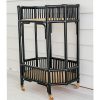 black rattan bar cart against cladded wall