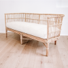Rattan lounge with white seat cushion