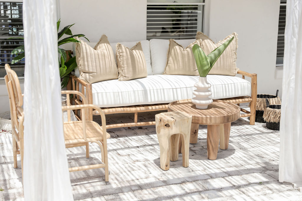 teak lounge with white seat cushions with coffee tables and white back ground