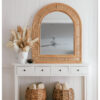 natural rattan mirror sitting on a console talbe