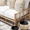 teak lounge with white seat cushions with black baskets on the ground