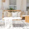 outdoor hanging chair with white pillows and throw