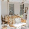 outdoor hanging chair with white pillows and throw