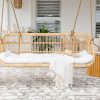 huge hanging chair with white pillows and a throw