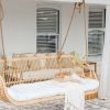 huge hanging chair with white pillows and a throw