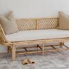 Small rattan lounge with 2 beige cushions on top