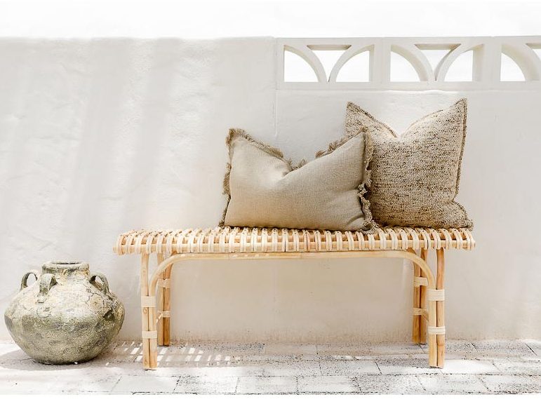 rattan bench seat with grey cushions on top