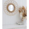 rattan round mirror hanging over white console