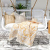 white hanging chair with yellow throw